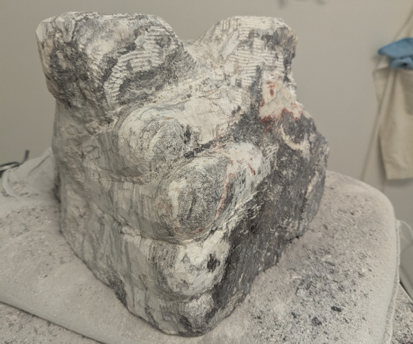 a sculpture depicting a head being held by a hand with brains oozing out of it