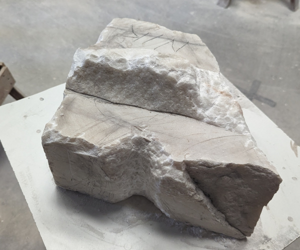 a sculpture made from marble showing a nude male figure