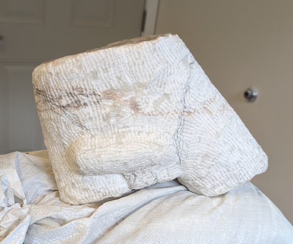a sculpture made from marble showing a nude male figure
